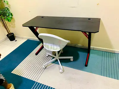 Black gaming/office desk with cable grommets — good condition