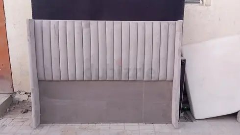 Grey upholstered king-size headboard with vertical channel tufting