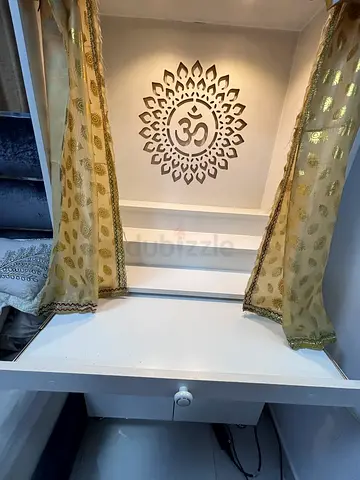 White mandir/hindu temple with shelf/cabinet with curtain and decorative backdrop