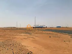 For sale in Rawdat Al-Qurt: a residential corner plot facing two 24-meter streets, ready for constru