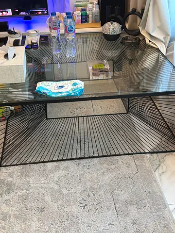 Glass top coffee table with black metal wire base - good condition