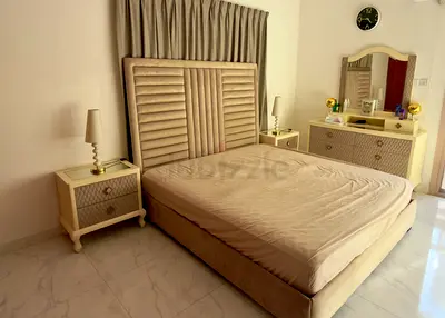 Beige upholstered queen bed with dresser and two nightstands – complete bedroom set