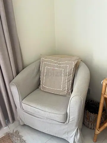 Light grey upholstered armchair with removable slipcover