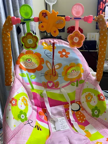 Pink floral baby bouncer seat with toy bar - good condition