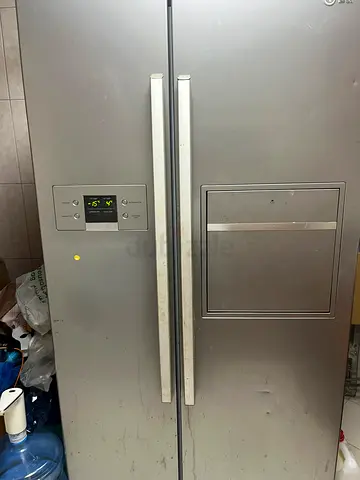 LG- Large silver side-by-side refrigerator with water dispenser - used