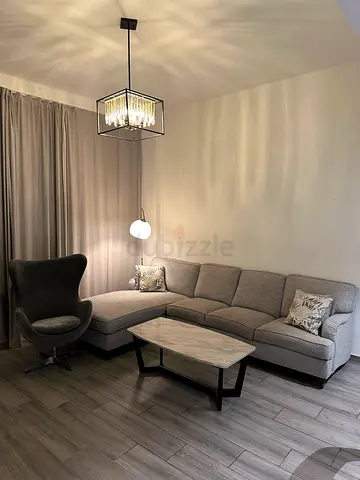 Light grey L-shaped corner sofa with matching armchair and coffee table