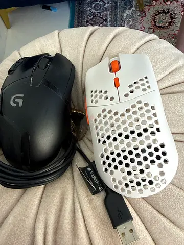 Pair of Logitech wired gaming mice – one white honeycomb and one black G-series