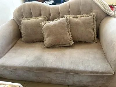 Two-seater beige velvet sofa with three cushions - good condition