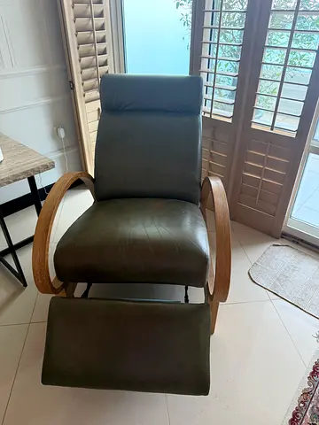 Comfortable green leather reclining armchair with matching footstool