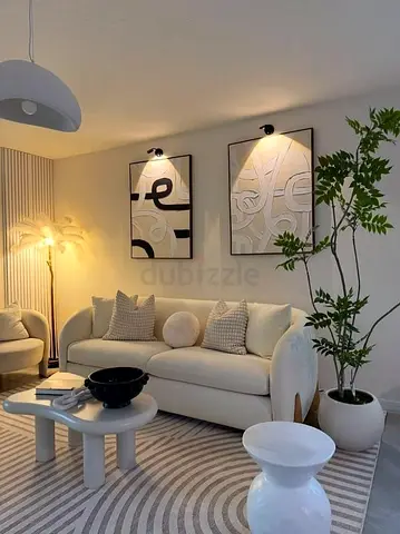 Cream modern 3-seater sofa with cushions and matching coffee tables