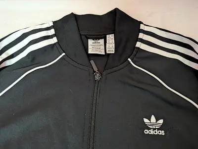 adidas Originals SST Track Jacket in black with signature white 3-Stripes.