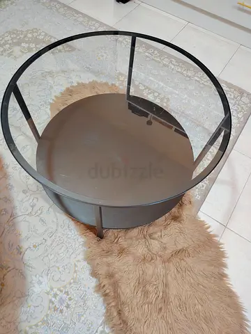Round glass-top coffee table with black metal frame