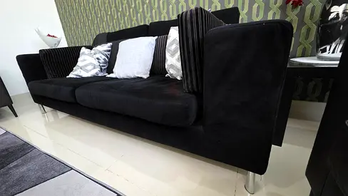 Black three-seater fabric sofa in good condition