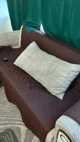 Brown quilted sofa cover with large beige lumbar cushion - used