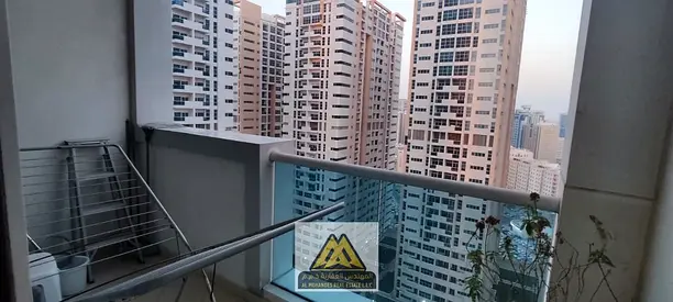 For sale in Ajman One Towers, Al Rashidiya 3: 2 bedrooms, living room, balcony with open garden vie