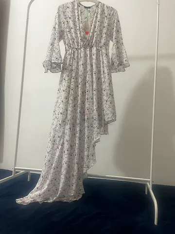 فستان باللون الأبيض مزين بالزهور و شكله المميز