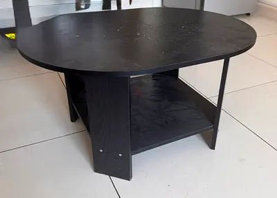 Used black oval coffee table with lower shelf
