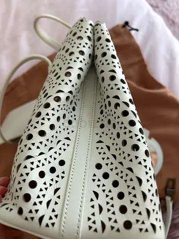 Alaïa Mina 25 tote in white Vienne laser-cut calfskin.
