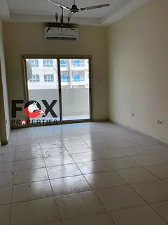 Room and living room for annual rent in Emirates City, with parking, balcony with open view, spaciou