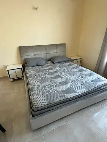 Grey upholstered double bed frame with headboard and mattress (good condition), dresser.