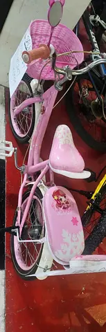 Pink childrens bicycle with training wheels and basket - good condition