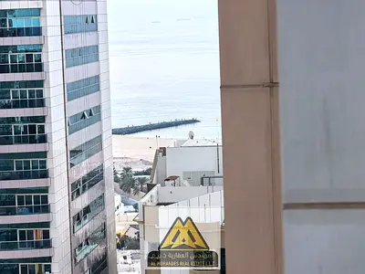 For sale in Ajman One Towers, near all services and close to the Corniche: two bedrooms and a large living room with a balcony and a view. Multiple mo