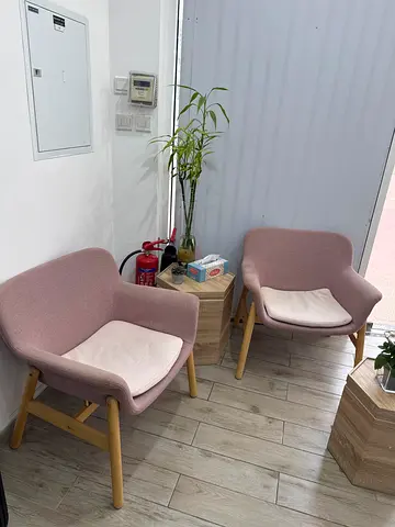 Pair of pink fabric accent chairs with wooden legs