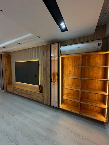 Custom Built-in Wooden Entertainment Wall Unit with Shelving and LED Lighting