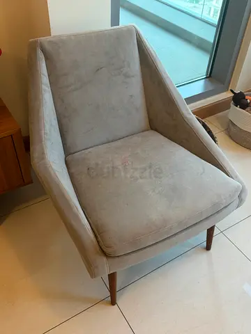 Light grey velvet upholstered accent armchair with wooden legs.