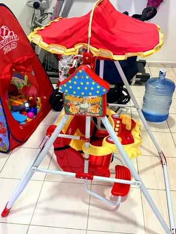 Red baby stroller/ride-on with canopy and activity tray.. swing