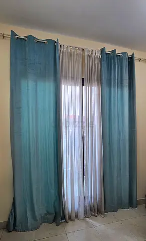 Pair of teal blackout curtains with sheer inner panel