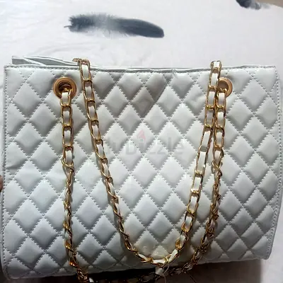White quilted shoulder bag with gold chain handles