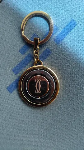 Gold-tone round metal keychain with swivel emblem