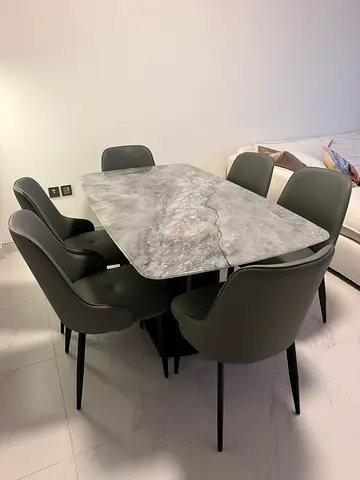 Modern marble dining table with 6 grey upholstered chairs