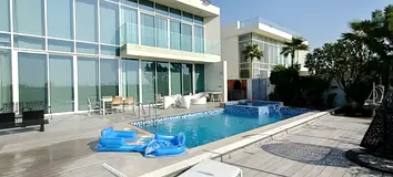 Villa for sale in Al Zorah, Ajman, featuring a view of the golf courses and a private swimming pool.