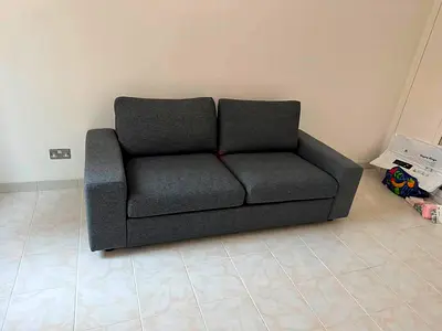 Comfortable 2-seater grey fabric sofa bed - good condition