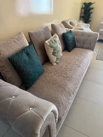 Light grey upholstered 3-seater sofa with decorative cushions