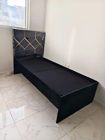 Single black upholstered bed frame with diamond-tufted headboard