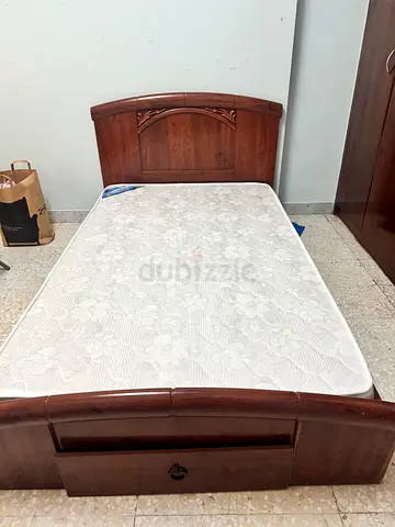 Single wooden bed frame with mattress and storage drawer
