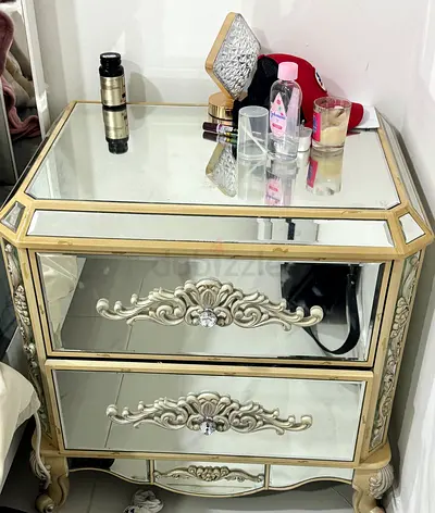Glass mirrored bedside table with ornate drawer details - gold trim
