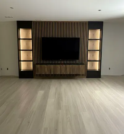 Custom wall-mounted entertainment unit with backlit display shelves