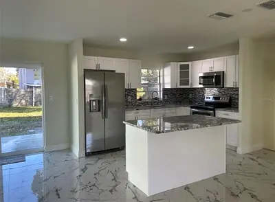 Modern white kitchen with island —and top granite with storage
