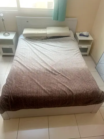 White wooden double bed frame with headboard and bedside tables