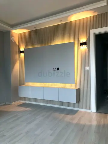 Modern wall-mounted TV unit with backlit panel and floating cabinet