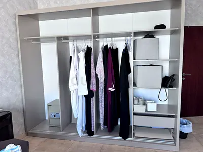 Open wardrobe/closet organizer with hanging rails and storage shelves