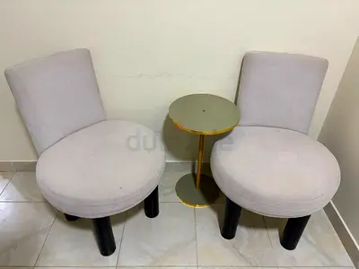 Pair of modern round beige accent chairs with small gold side table