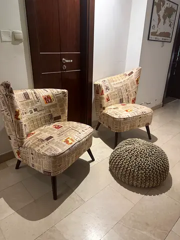 Pair of newspaper-print accent chairs with wooden legs. Used for 2 years