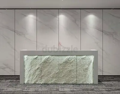 Modern reception counter with textured stone front, marble backdrop