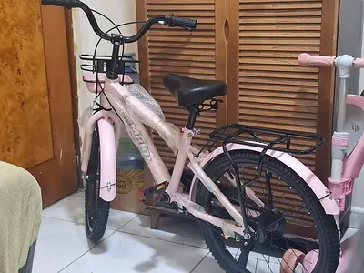 Never used pink childrens bike with rear carrier and training wheels