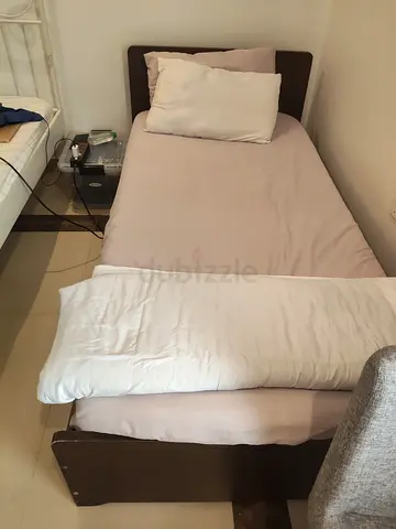 Single wooden bed frame with mattress and bedding